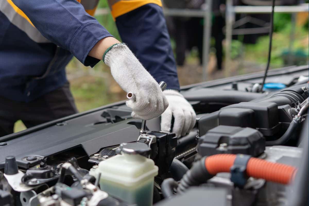 A technician performing maintenance on a vehicle's engine