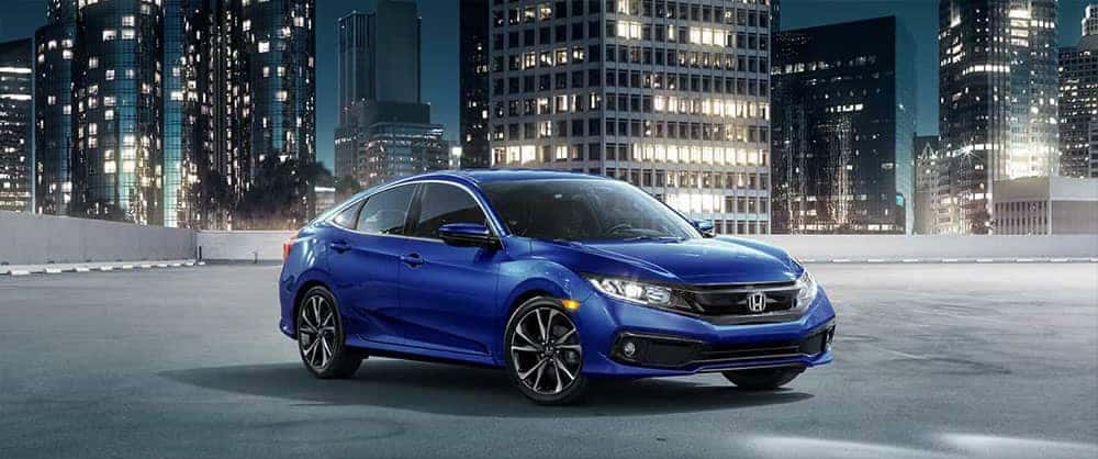 Side view of a blue 2019 Honda Civic parked on a city rooftop at night