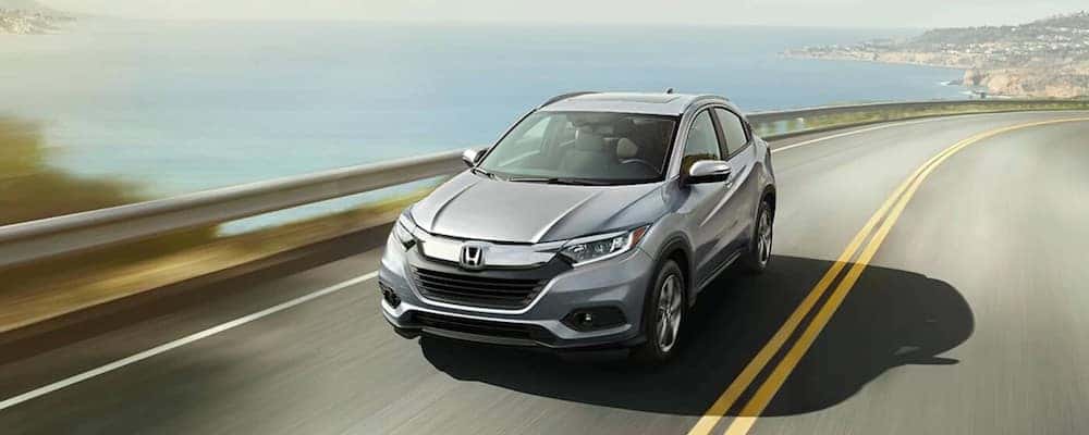 Front top view of a silver 2020 Honda HR-V driving down a water-side road