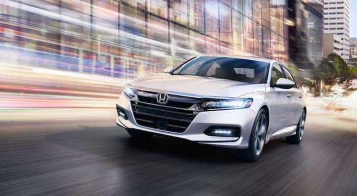 Front view of a white 2020 Honda Accord Touring driving through the city