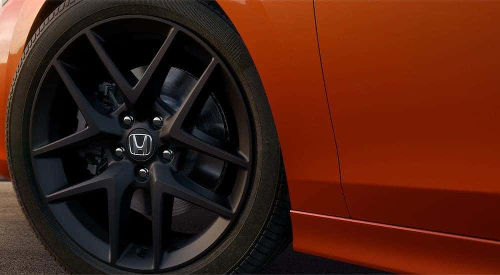 A close up of the tire on an orange 2022 Honda Civic Si