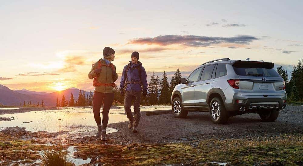 A silver 2022 Honda Passport Trailsport is shown from the rear at an angle after leaving a dealer that has a Honda Passport for sale.