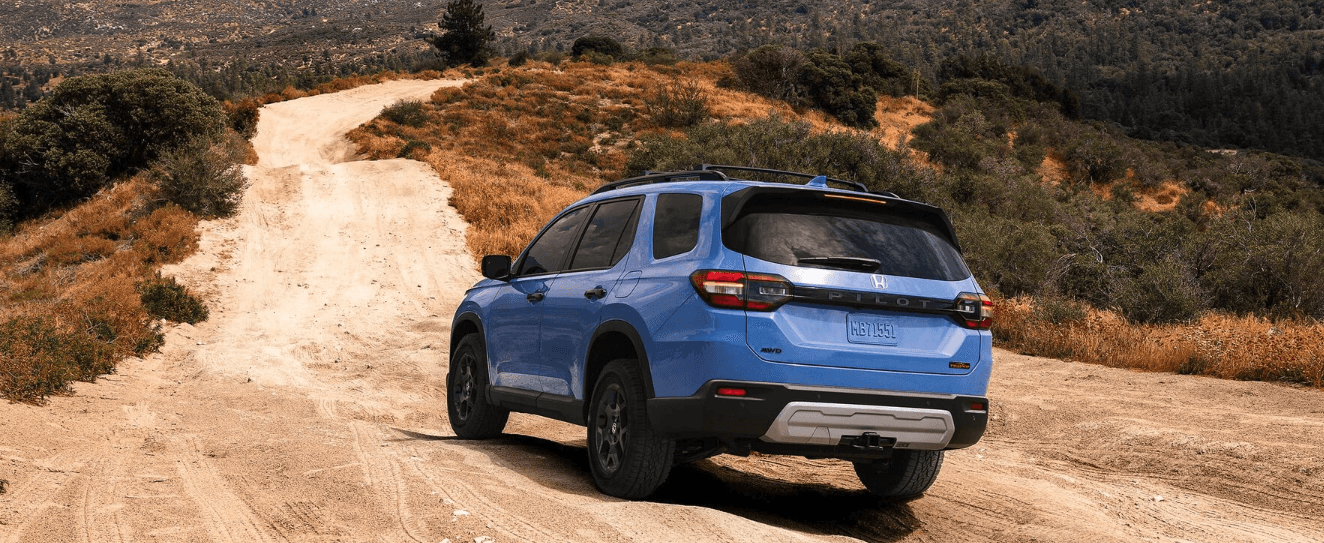Rear view of the 2024 Honda Pilot Trailsport in an off-road setting