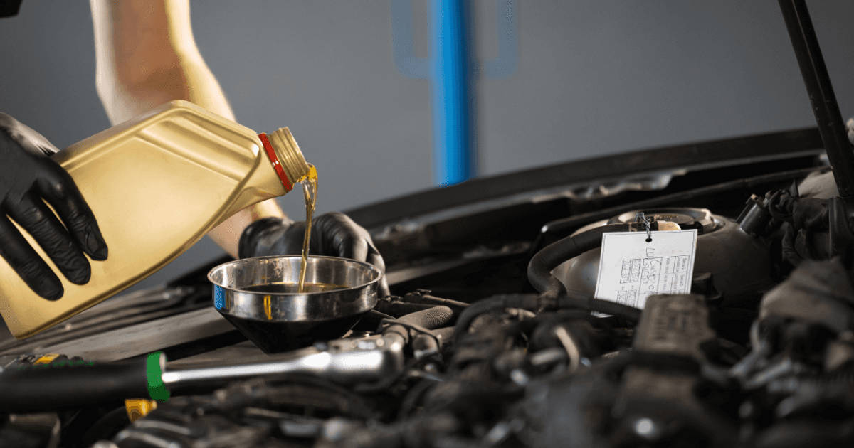 A service technician performing an oil change on a vehicle
