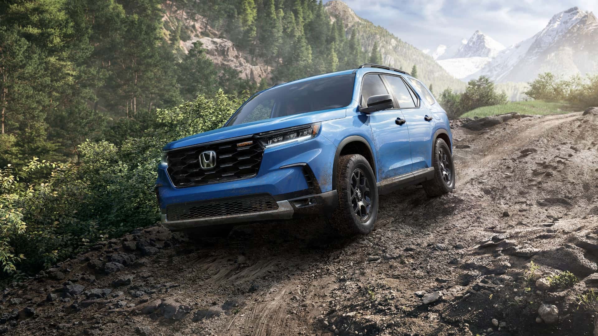 A blue Honda Pilot descending a dirt road on a mountain