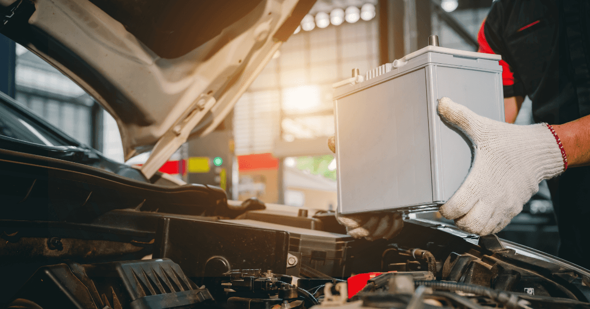 A technician replacing a vehicle's battery