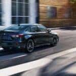 A black Honda Civic Hybrid driving down the road