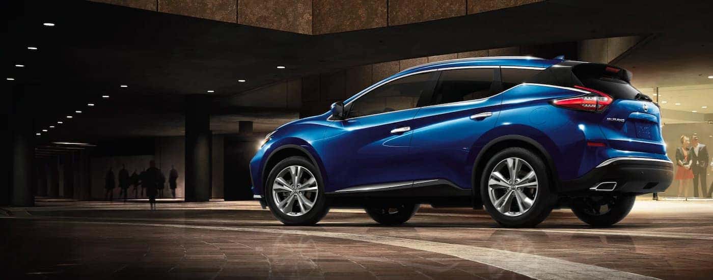 A blue 2021 Nissan Murano is shown from the side parked outside of a used Nissan dealership.