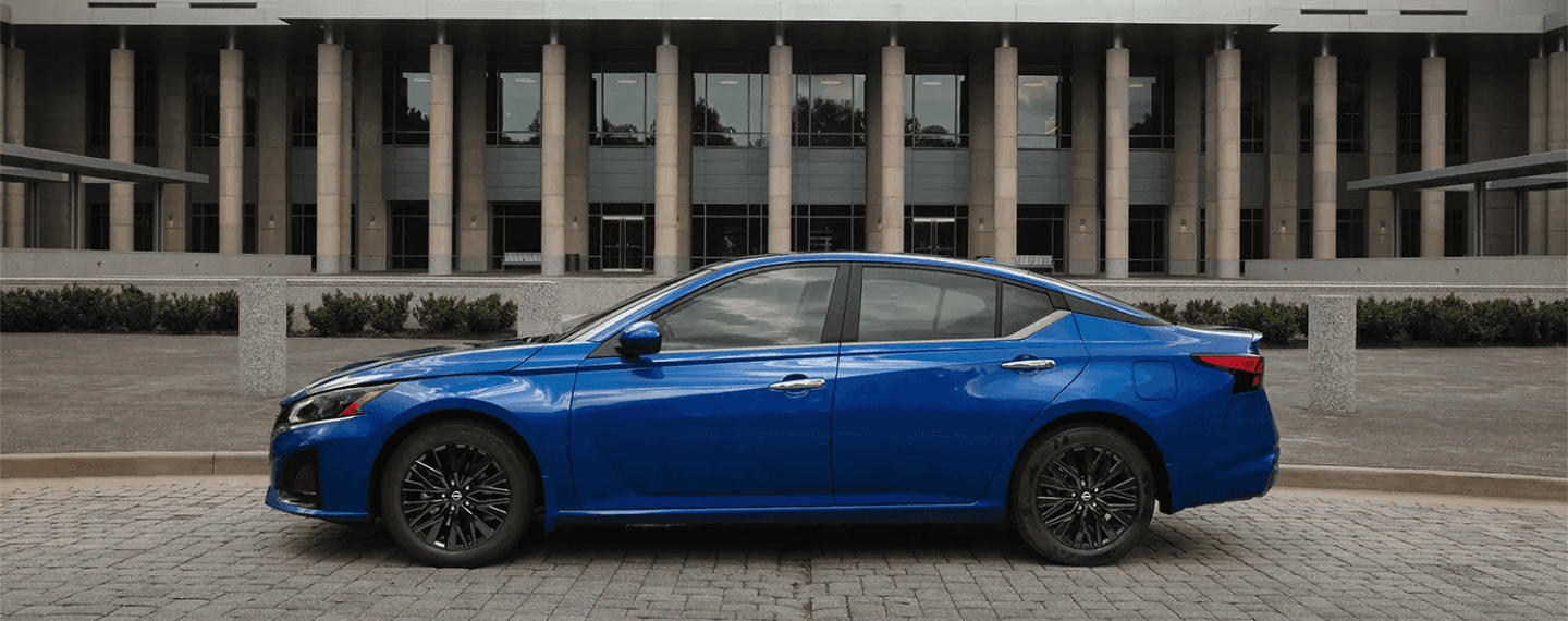 Side profile of the 2025 Nissan Altima parked in front of a building