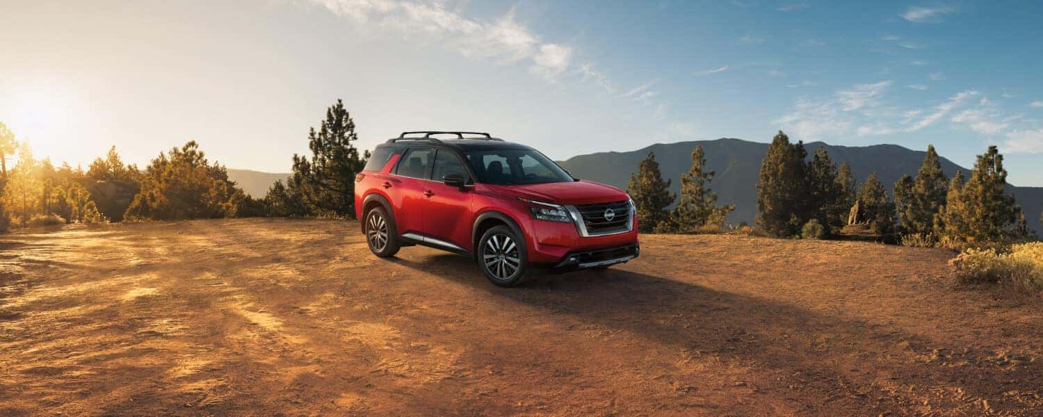 A red 2025 Nissan Pathfinder, parked on a cliff