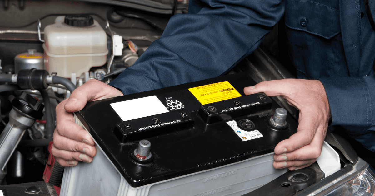 A mechanic performing a battery replacement with a vehicle
