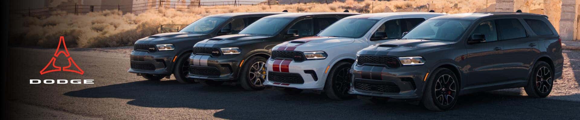 Front three-quarter view of 2027 Dodge Durango SRT models lined up in a desert with mountains.