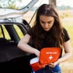 Girl looking through car first aid kit