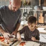 Father with two kids preparing pizza at home