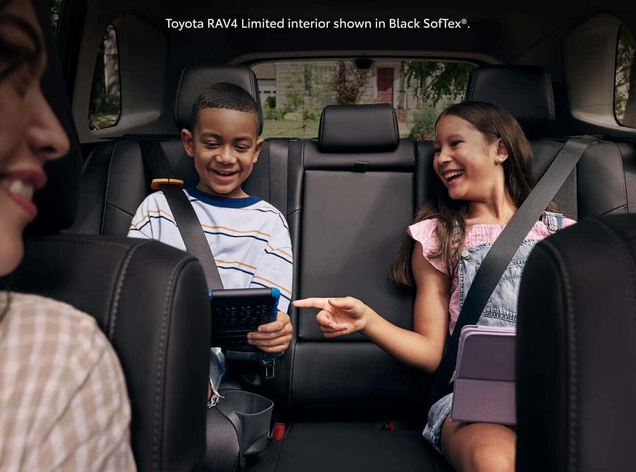 Interior rear seat view of the 2026 Toyota RAV4 Limited in Black SofTex®, showing two kids in the back seat.