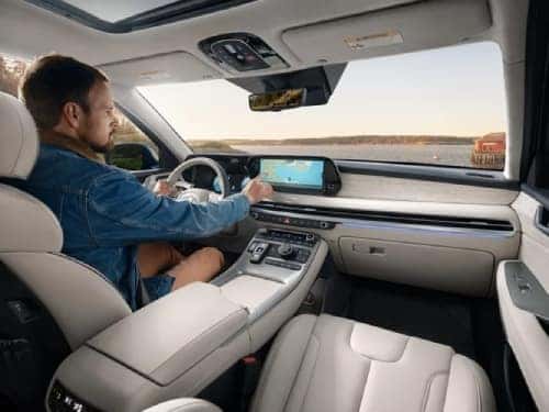 2025 Hyundai PALISADE view of man in driver seat using touchscreen navigation