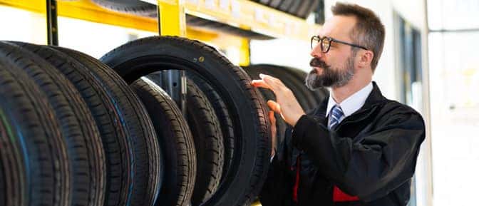 A person holding a tire.