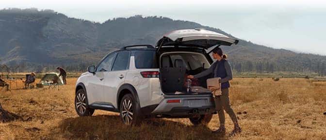 A person loading gear into the trunk of a car