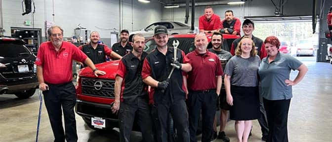 Group of people posing in front of a red truck