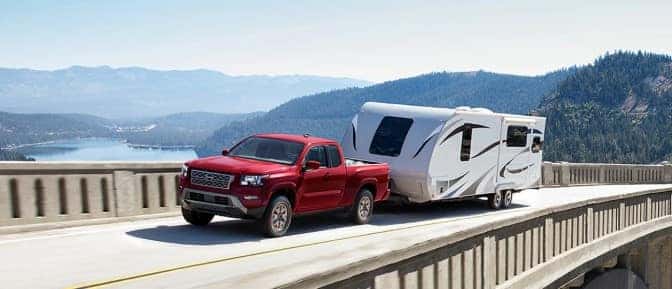 A red truck towing a white camper