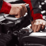 A close-up of a mechanic working on a car engine