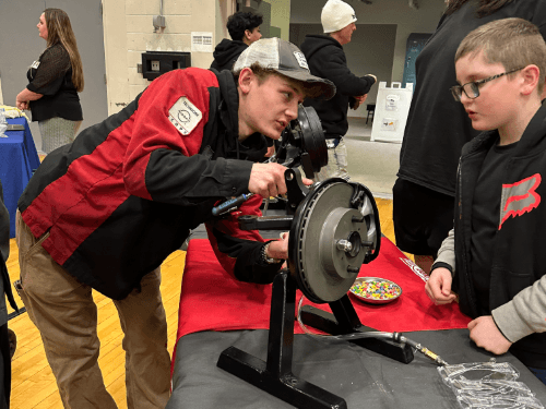 A person looking at a car part