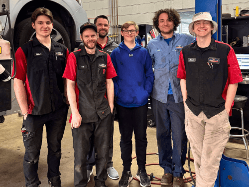 A group of people standing in a garage
