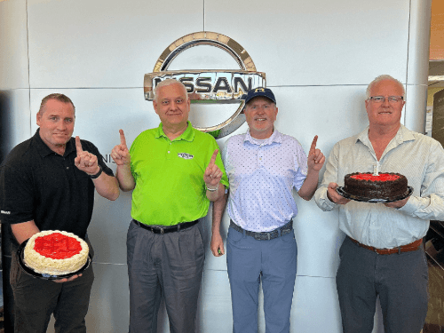 A group of men holding a cake