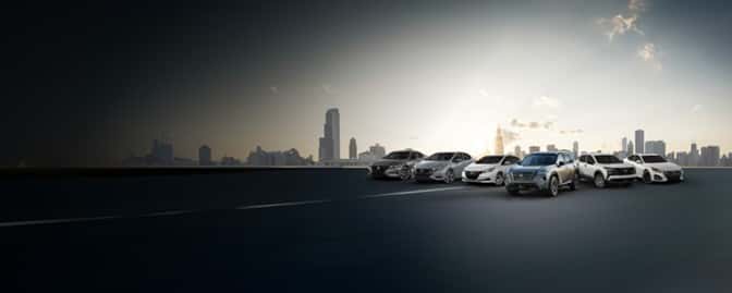 Nissan model lineup parked with a city skyline shown in the background