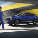 A person walking next to a blue car