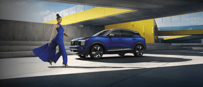 A person walking next to a blue car