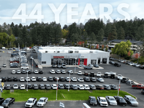 A parking lot with cars and trees in the background