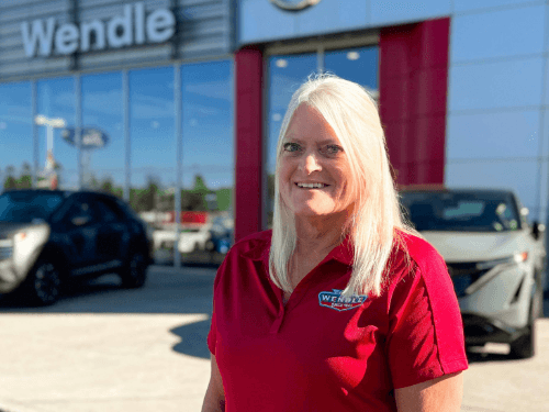 Employee standing in front of Wendle Nissan dealership