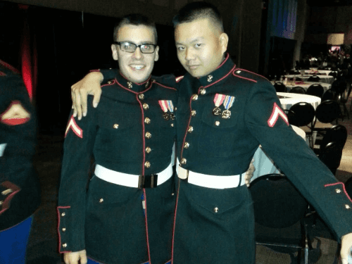 Two U.S. Marines in their Dress Blue uniforms, posing at a formal military event.