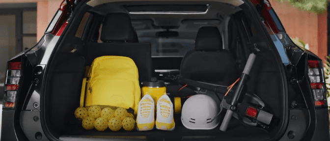 The cargo area of a 2025 Nissan Kicks with a bag and sports equipment