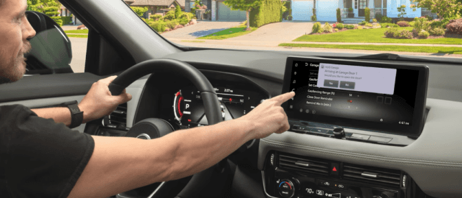 A driver using the NissanConnect touchscreen inside a vehicle to operate a garage door via the myQ Garage interface.