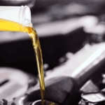 -up of fresh motor oil being poured into an engine during a vehicle service.-up of fresh motor oil being poured into an engine during a vehicle service.