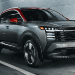 Two-tone gray and red Nissan Kicks SR crossover driving inside a modern futuristic roadway tunnel.