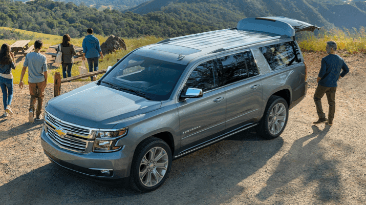 A family standing outside of a GMC SUV - exterior shot