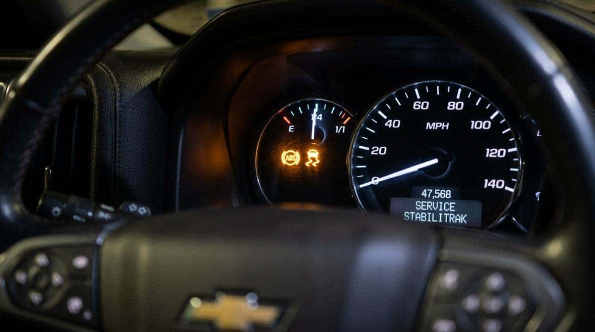 ABS and traction control warning lights illuminated on Chevrolet dashboard requiring service at a certified GM dealership