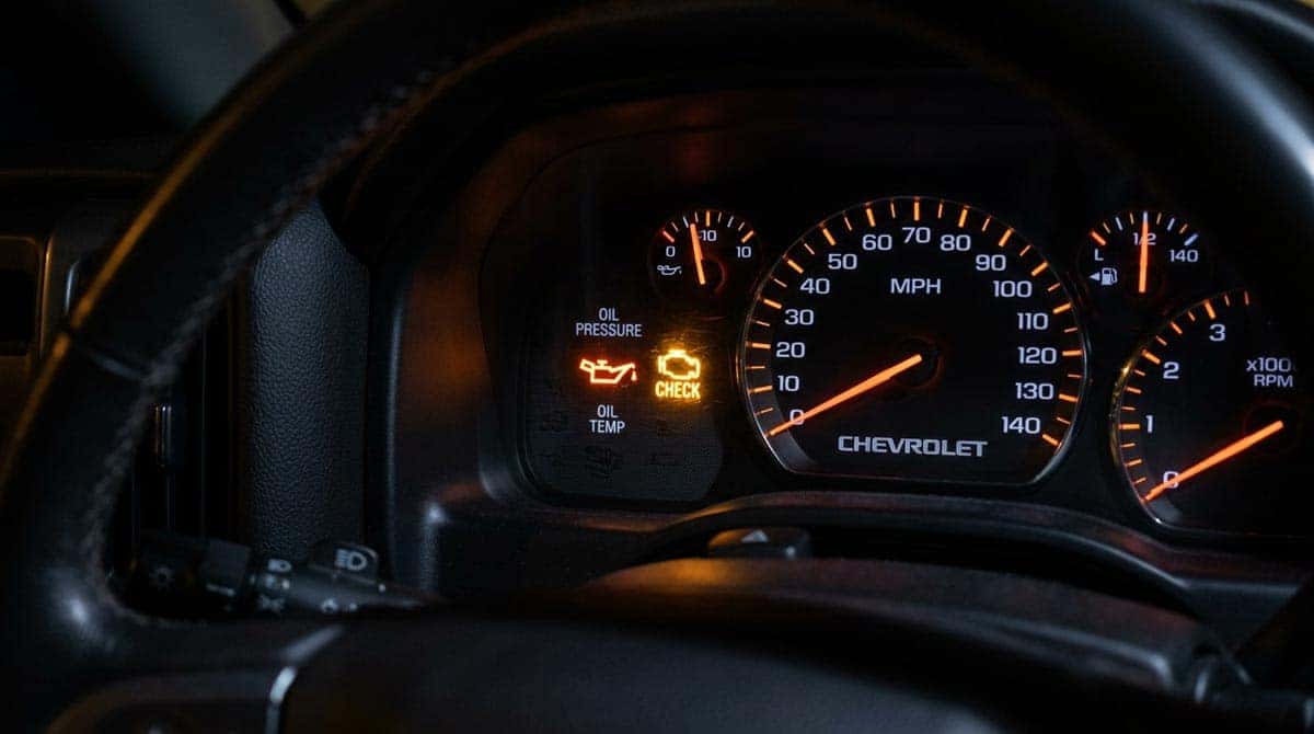 Low oil pressure warning light and check engine light illuminated on Chevrolet Silverado instrument cluster dashboard